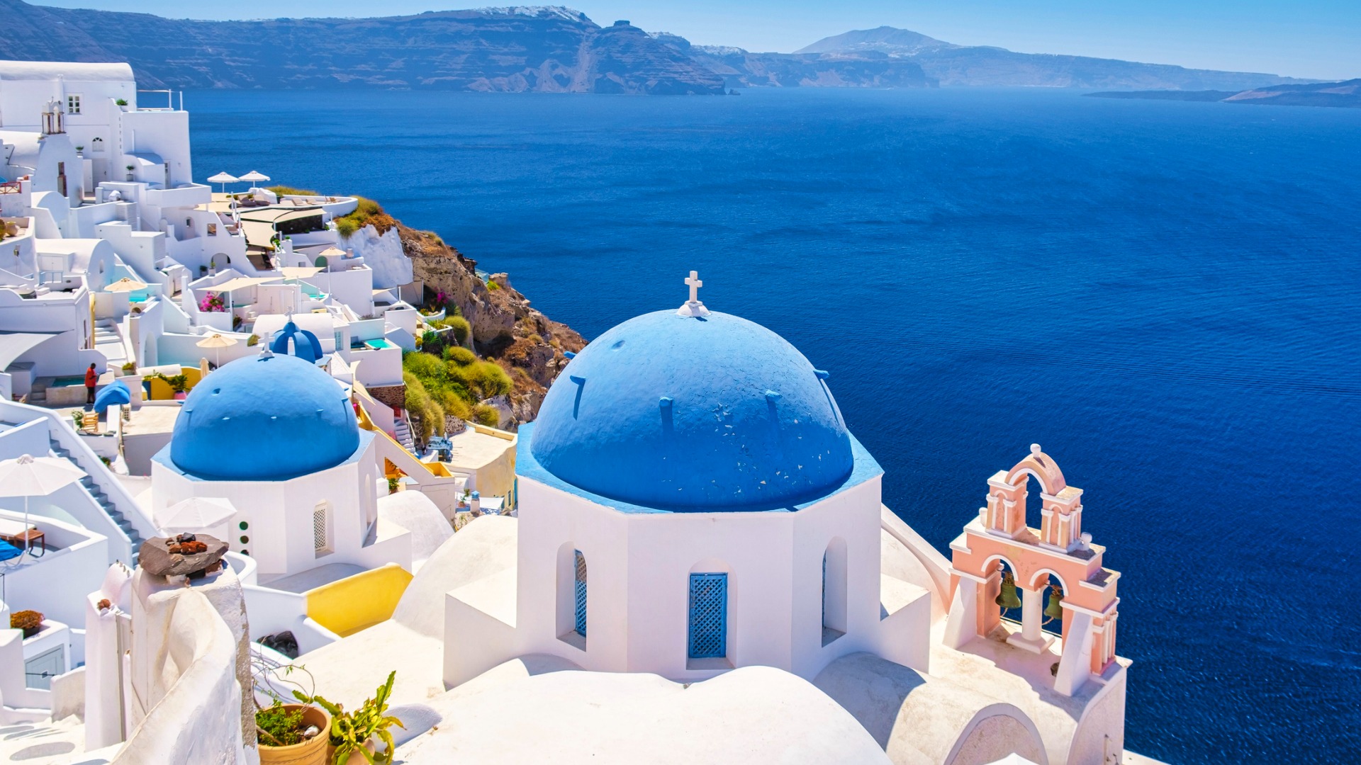 white-churches-an-blue-domes-by-the-ocean-of-oia-santorini-greece-traditional-greek-village